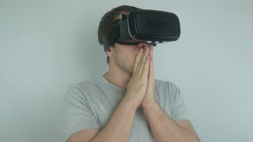 Man Wearing VR Headset Clasping Hands