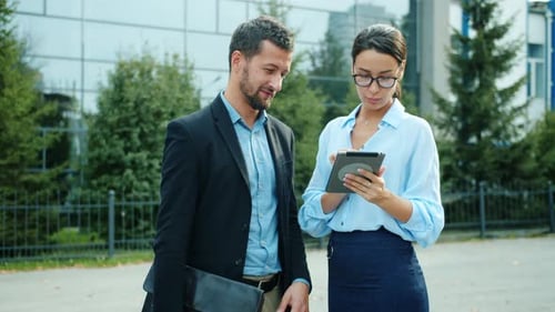 Business Colleagues Working Together on Tablet Outside Office