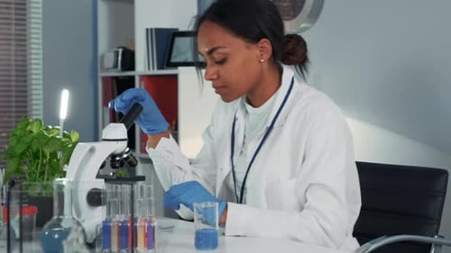 Woman Working With Microscope in Laboratory
