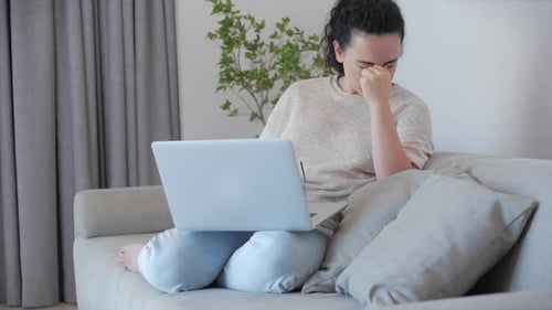 Woman Looking Tired While Working on Laptop