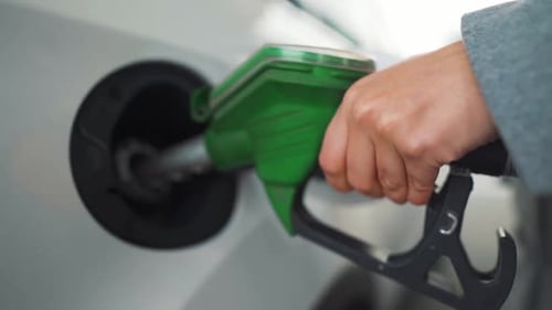 Frau füllt Benzin in Nahaufnahme einer Tankstelle in ihr Auto. Zeitlupe