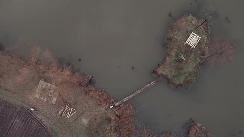 Aerial drone view of beautiful lake with two cyclists riding on bicycles