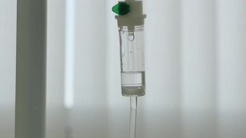 Close Shot Dropper Patient On Background Blinds Window In Ward Dripping Running. Concept Hospital