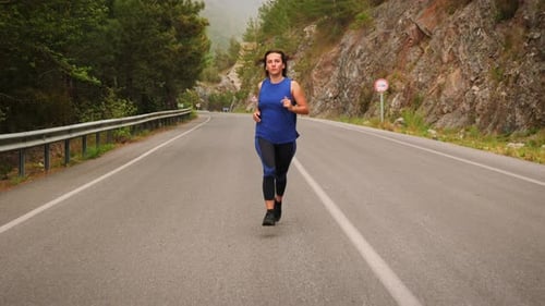 Woman Runs Along Mountain Road for Exercise
