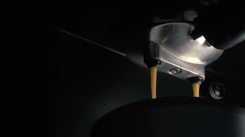 Pouring coffee stream from professional machine in cup. Flowing fresh ground coffee in the morning