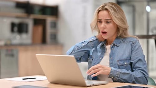 Woman Massaging Neck While Working on Laptop