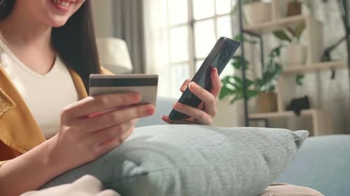 Woman Shopping Online with Credit Card on Sofa