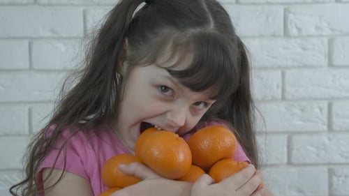 Child Eating Tangerine Pile at Home