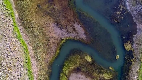 Luftaufnahme des bunten Flusses, der in den See fließt, von oben