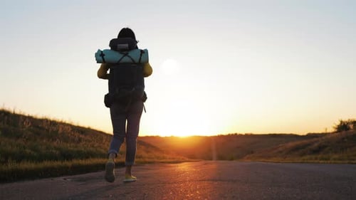 Female Hiker Walks Into Golden Sunset