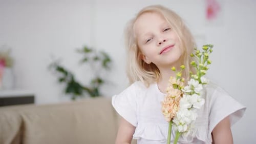 Fair-Haired Girl Smelling Flowers Smiling Sweetly