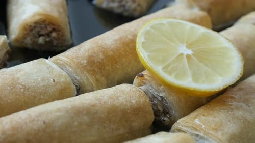 Sirop de sucre sucré avec tranches de citron sur pâte filo, rouleaux de baklawa panoramiques 4K 2160p, 30 images par seconde, vidéo UHD