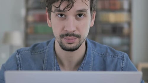 Man smiles while working indoors at home