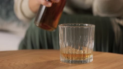 Pouring Liquor Into Glass at Home Indoors