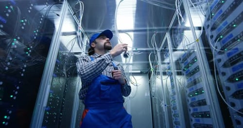 Technician Checking Cables at a Data Center