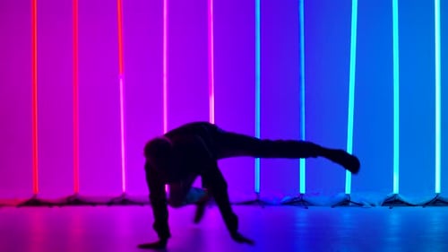 A Professional Breakdancer Performs Complex Hand Rotations. Silhouette of a Man Dancing Against the
