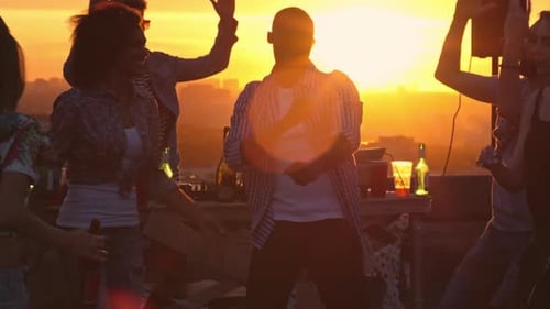 Joyful Friends Dancing at Sunset Rooftop Party