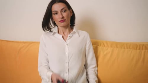 Woman Channel Surfing on Couch with Remote Control