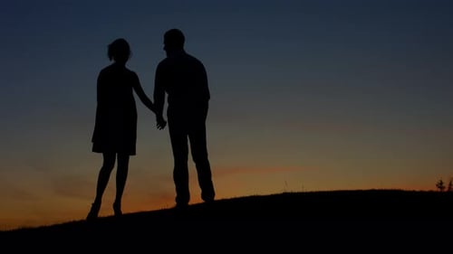 Silhouetted Couple Embrace at Sunrise