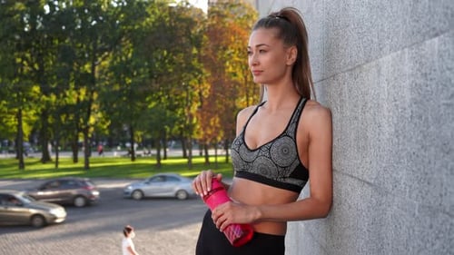 Fit Woman Resting After Exercise in City Park