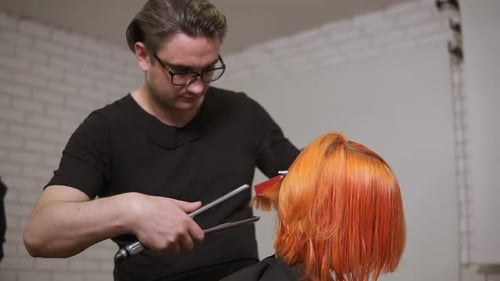 Hairstylist Straightens Orange Hair in Salon