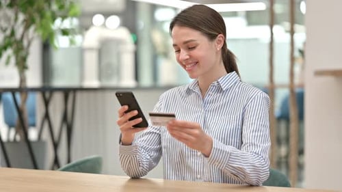 Young Woman with Online Payment Success on Smartphone in Office