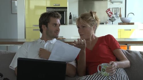 Couple Looking at Paper Together on Couch
