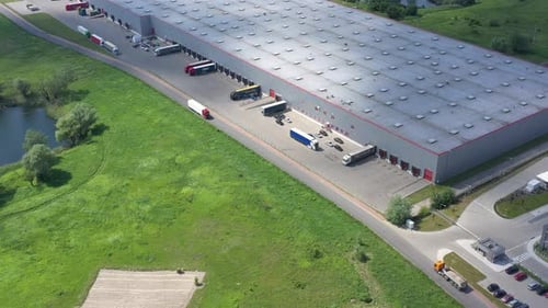 Aerial Shot of Truck with Attached Semi Trailer Leaving Warehouse complex -