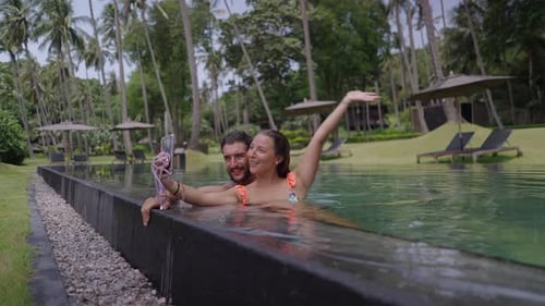 A Static Shot of a Happy Young Couple Taking Selfie Photo at Edge of Swimming Pool