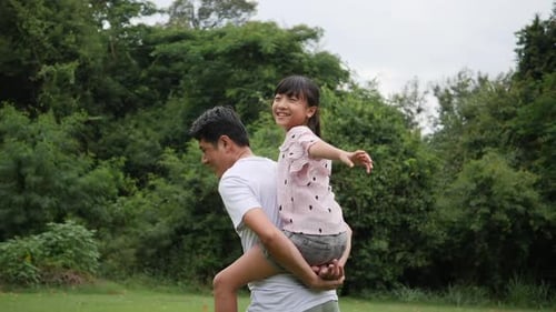 Joyful Father Daughter Piggyback Ride in Park