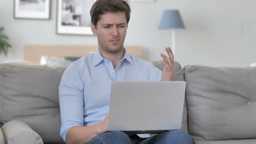 Frustrated Man Working on Laptop at Home