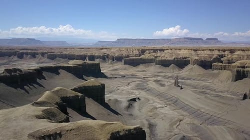 Aerial view flying over desert cliffs viewing eroded terrain below