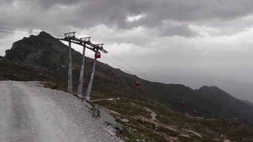 Red Aerial Tramway Against Gloomy Sky At Kitzsteinhorn Alps In Kaprun, Austria. - Aerial Shot