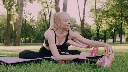 Women Stretching in the Park on Yoga Mats