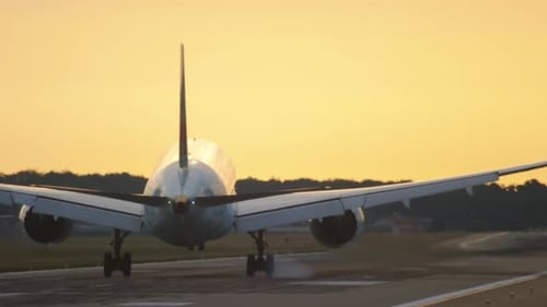 Plane Landing on Runway During Sunrise or Sunset