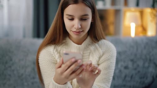 Woman Using Smartphone While Sitting on Couch