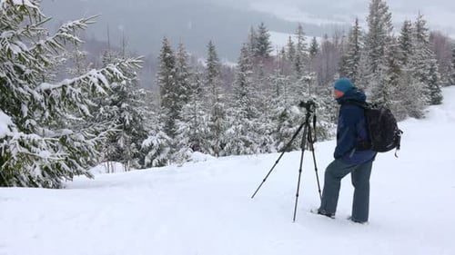 The Photographer Shoot a Mountain Forest in the Carpathians in Rainy and Snowy Weather