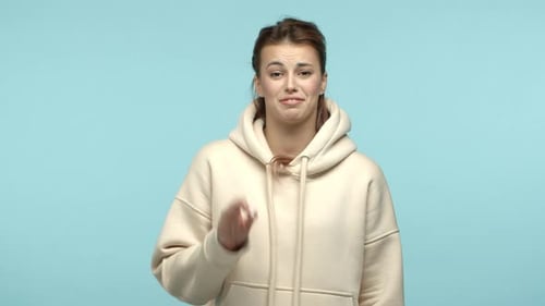 Zeitlupe einer stylischen, attraktiven Frau mit Kapuze, die okay sagt, Ok zeigt und Daumen hoch