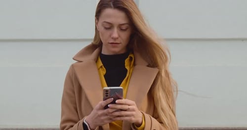 Woman with Smartphone Walking in the City