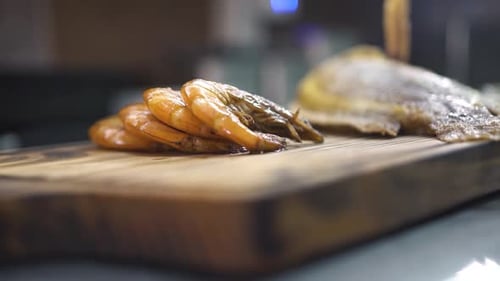 Arranging Grilled Shrimp and Fish on Wood Board