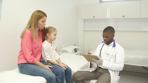 Doctor Consults with Young Patient and Mother