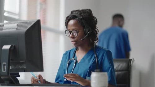 Medical Worker Talking on Headset at Desk