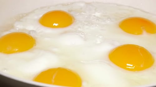 Fresh Fried Eggs Cooking in a Pan