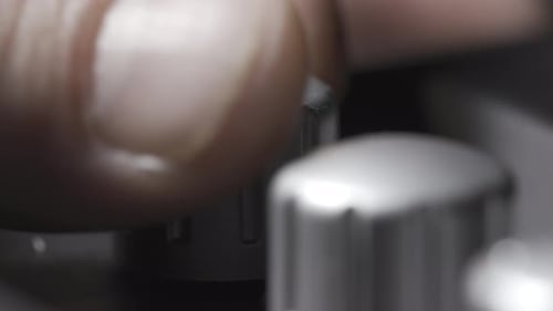 La mano gira el control de potencia para aumentar el volumen