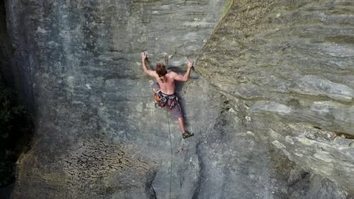 Man Rock Climbing Outdoors on Steep Rock Face
