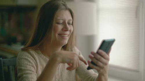 Woman Using Smartphone, Drinking Coffee Indoors
