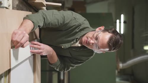 Male Carpenter in Green Shirt Wearing Safety Goggles for Woodworking