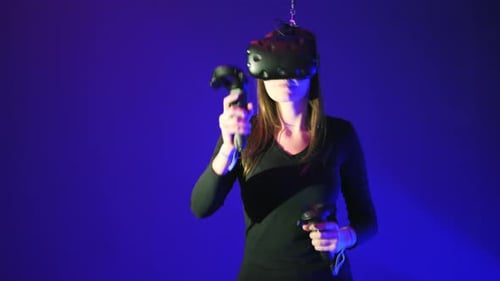 Woman Experiences Virtual Reality with Controllers and Headset