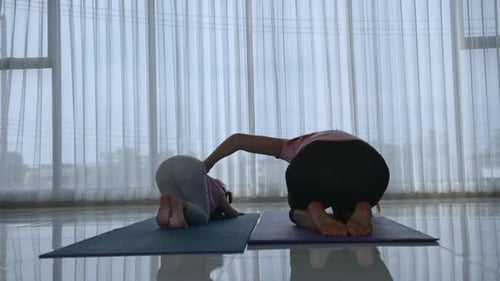 Girl and Adult Doing Yoga Poses Indoors