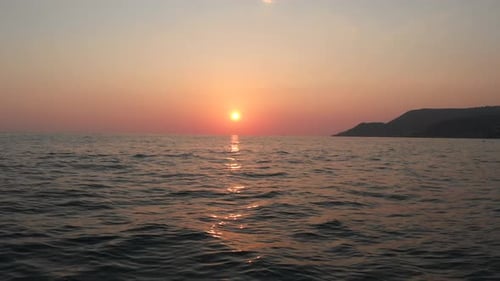 Scenic view from sailing ship on golden sunset in sky and sea waves